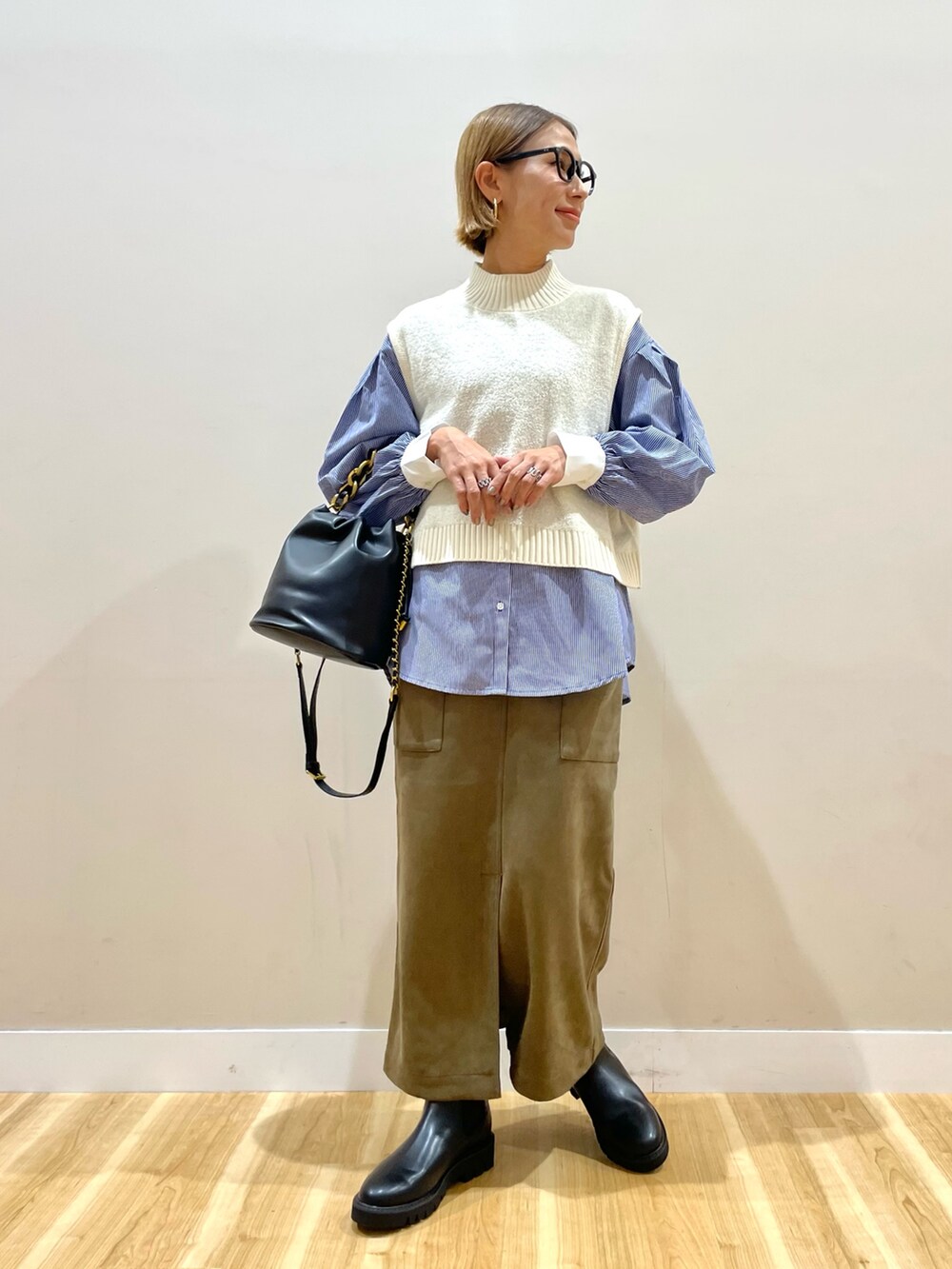 ホワイト系のニット/セーター、ブルー系のシャツ/ブラウス、グリーン系のスカートを着用したレディースの秋コーディネートの5枚目の写真