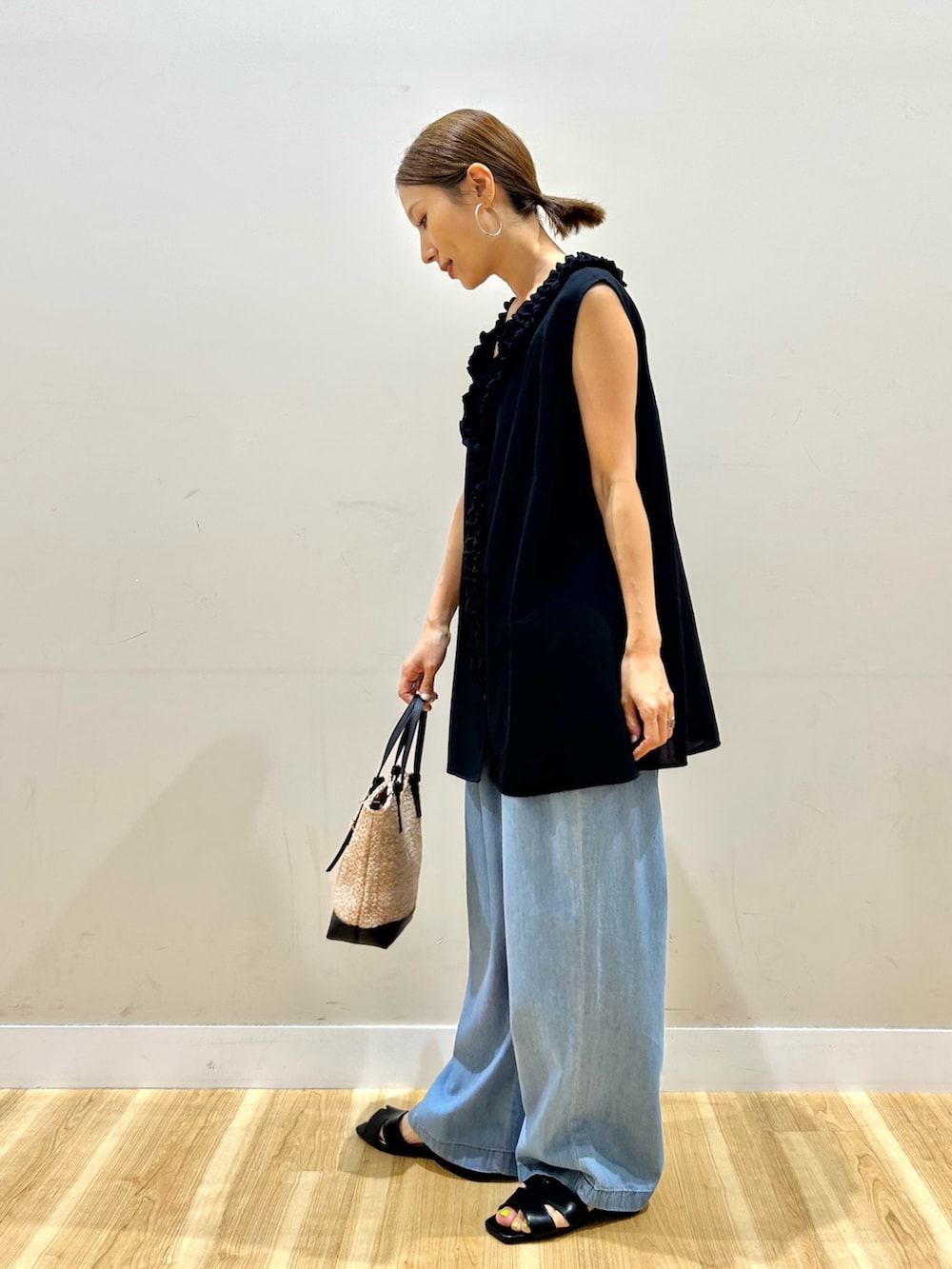 ブラック系のシャツ/ブラウス、ブルー系のデニムパンツ、ブラック系のショルダーバッグを着用したレディースの夏コーディネートの3枚目の写真