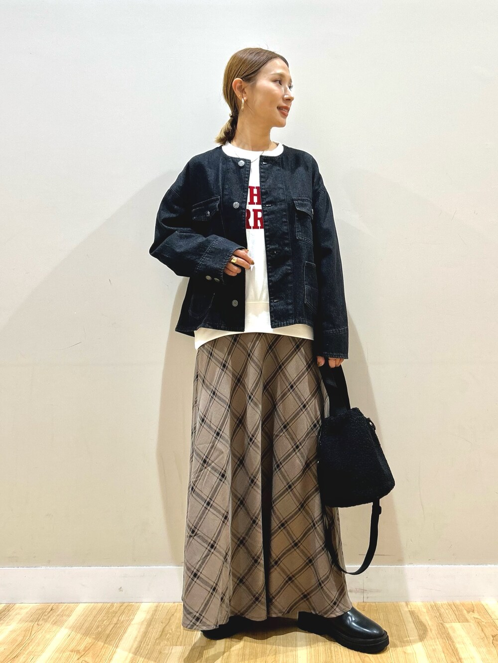 ブラック系のデニムジャケット、ホワイト系のスウェット、ブラウン系のスカートを着用したレディースの秋コーディネートの8枚目の写真