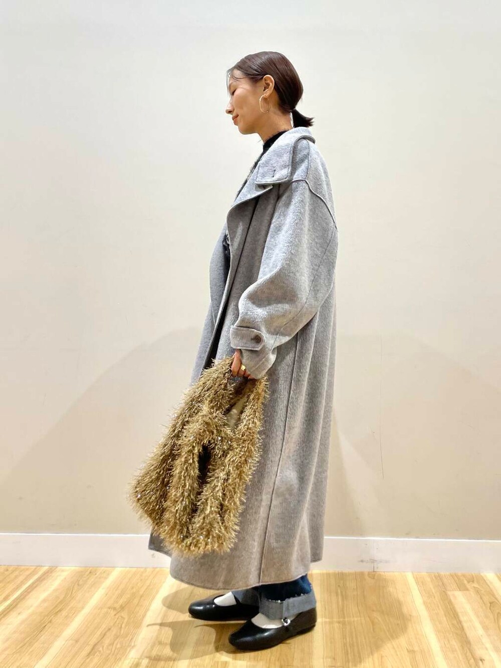 ブラック系のパンプス、ブルー系のデニムパンツ、グレー系のその他アウターを着用したレディースの冬コーディネートの6枚目の写真