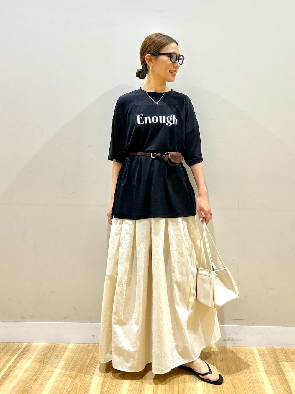 ブラック系のTシャツ/カットソー、ホワイト系のスカート、ホワイト系のハンドバッグを着用したレディースの夏コーディネートの5枚目の写真