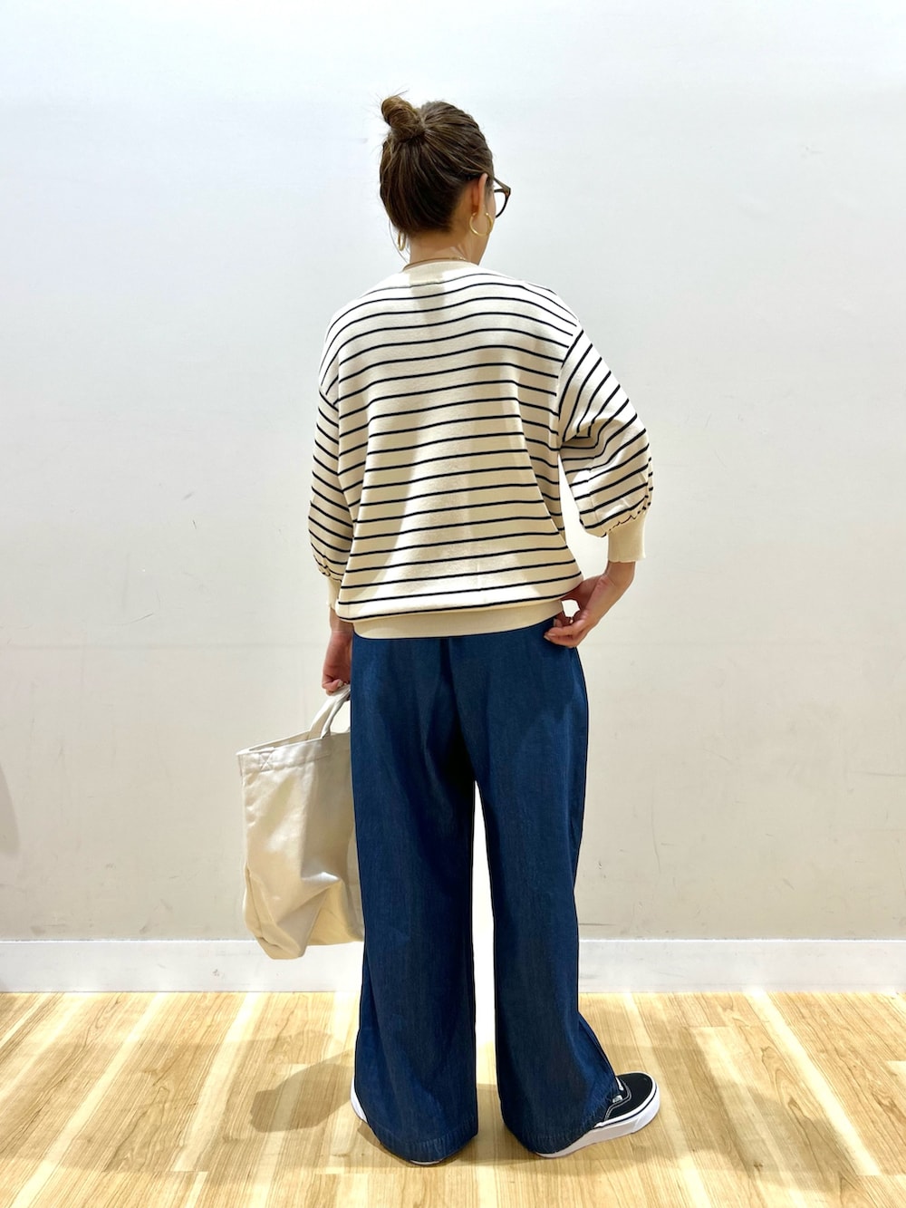 ベージュ系のマウンテンパーカー、ホワイト系のニット/セーター、ブルー系のその他パンツを着用したレディースの春コーディネートの6枚目の写真