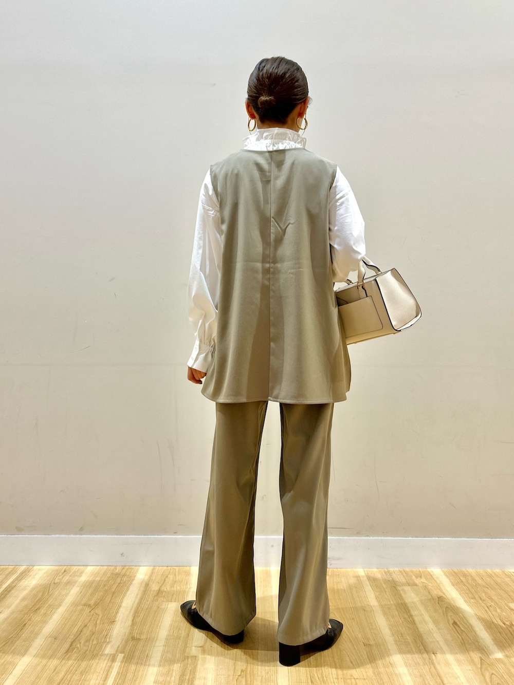 ベージュ系のセットアップ、ホワイト系のハンドバッグ、ホワイト系のシャツ/ブラウスを着用したレディースの冬コーディネートの3枚目の写真