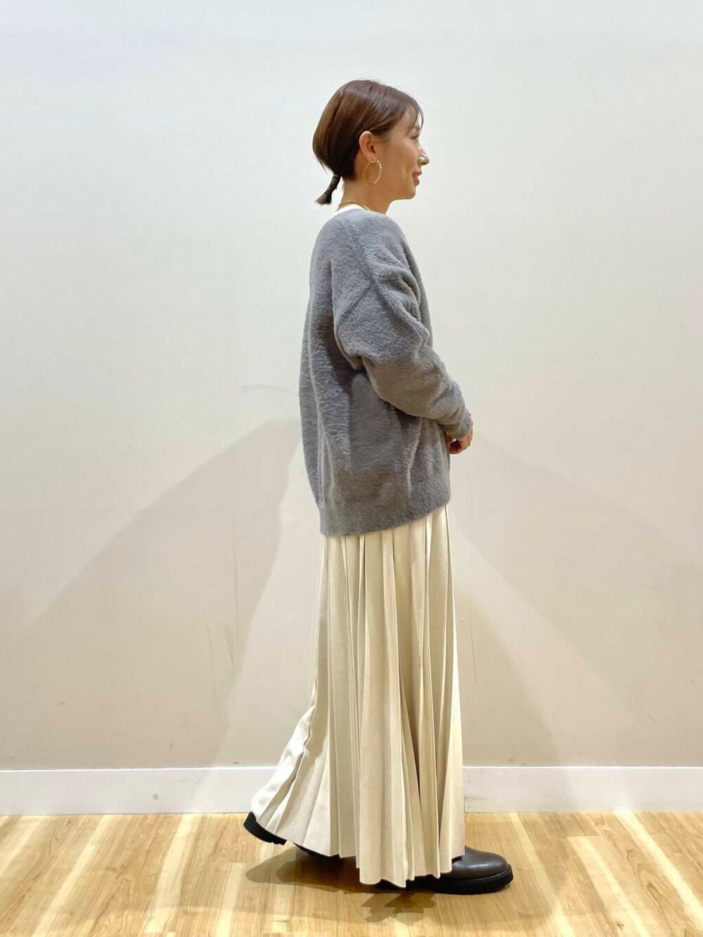 ベージュ系のスカート、ブラック系のブーツ、グレー系のダウンジャケット/コートを着用したレディースの冬コーディネートの8枚目の写真