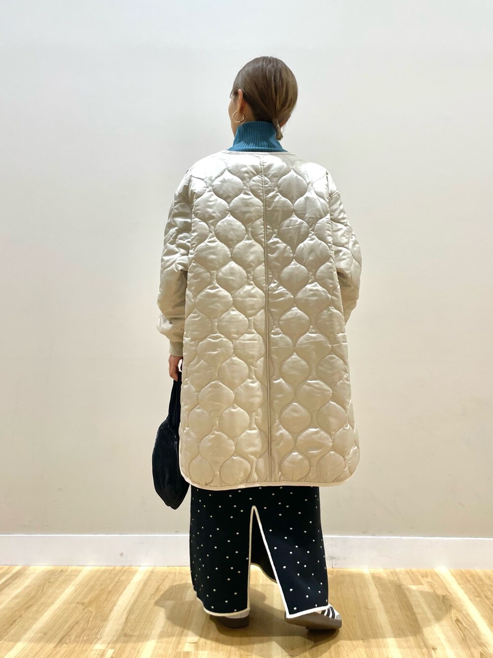 ベージュ系のその他アウター、ブラック系のスカート、ブルー系のニット/セーターを着用したレディースの冬コーディネートの3枚目の写真
