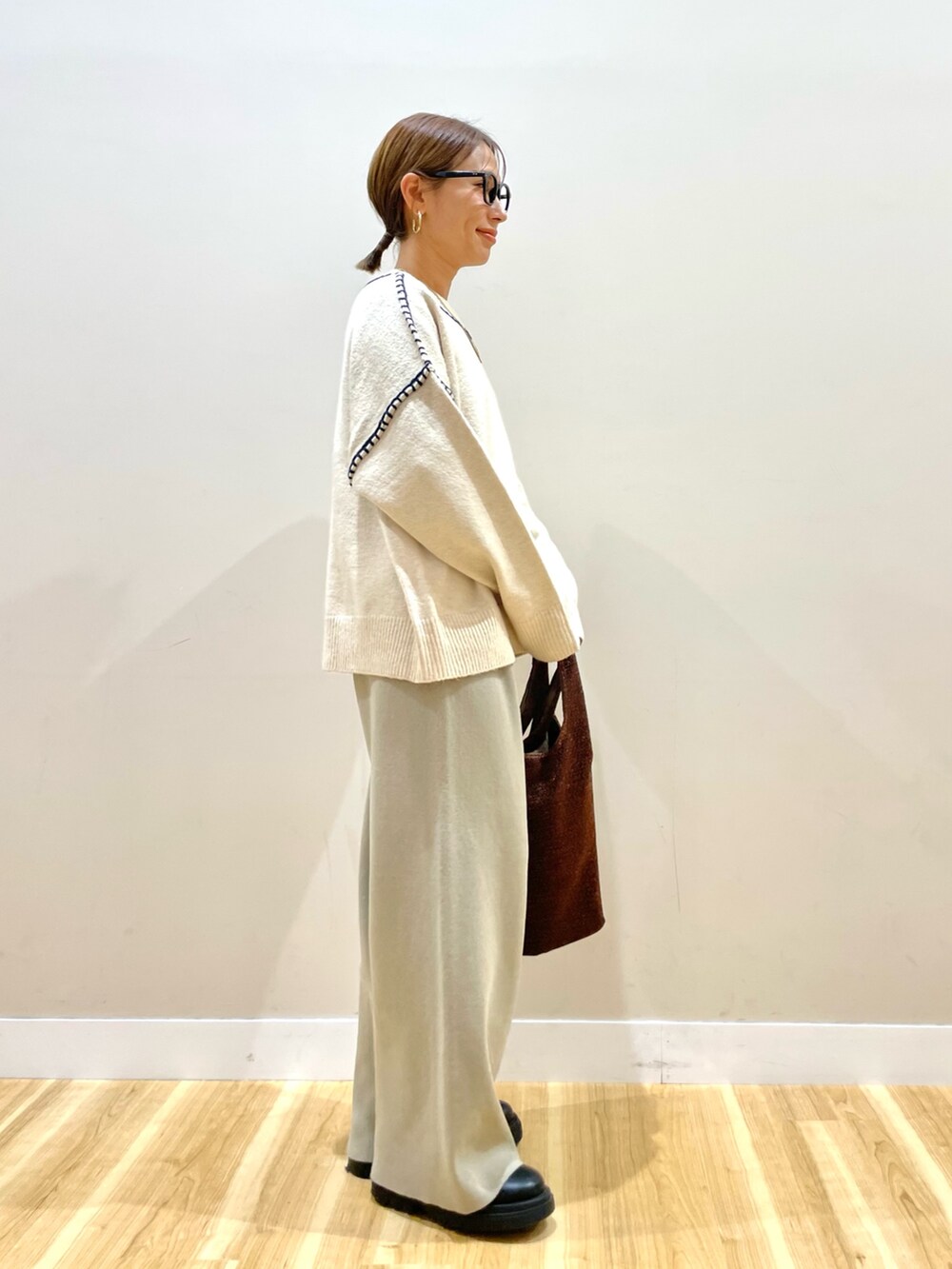 ブラック系のダウンジャケット/コート、ホワイト系のニット/セーター、ベージュ系のその他パンツを着用したレディースの冬コーディネートの7枚目の写真