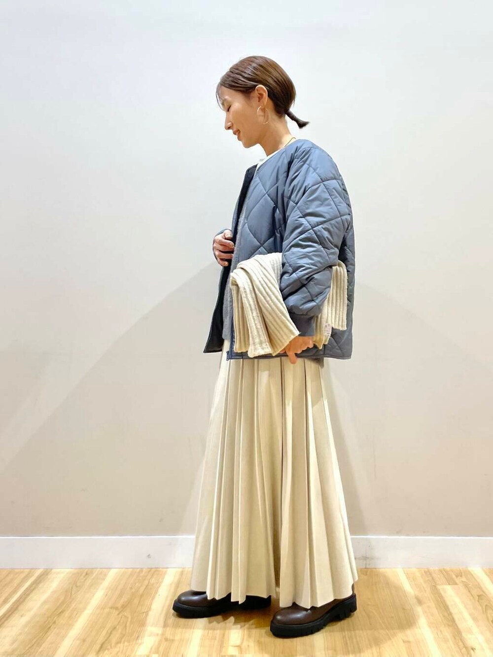 ベージュ系のスカート、ブラック系のブーツ、グレー系のダウンジャケット/コートを着用したレディースの冬コーディネートの5枚目の写真