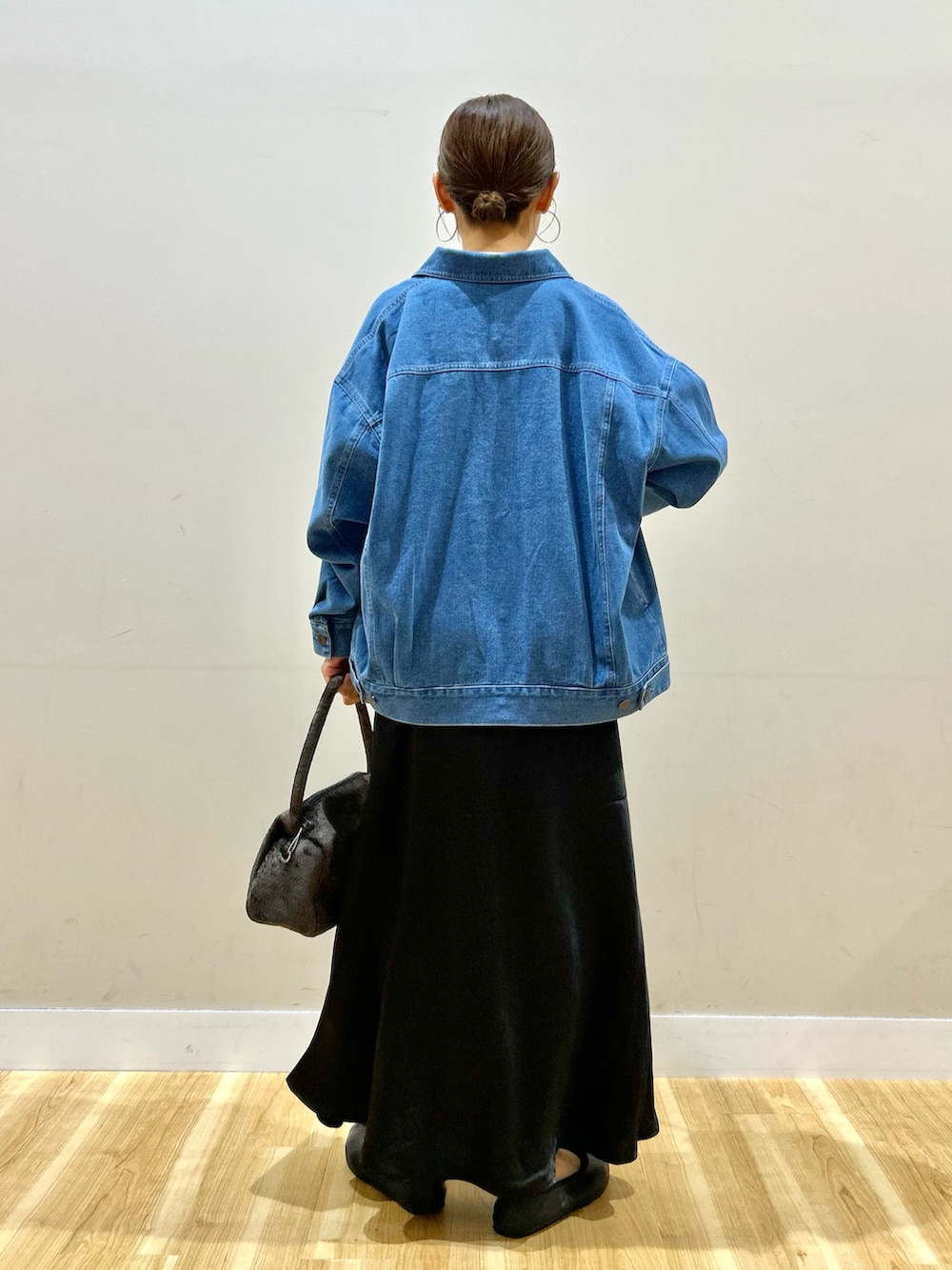 ブルー系のカバーオール、ホワイト系のTシャツ/カットソー、ブラック系のスカートを着用したレディースの秋コーディネートの3枚目の写真