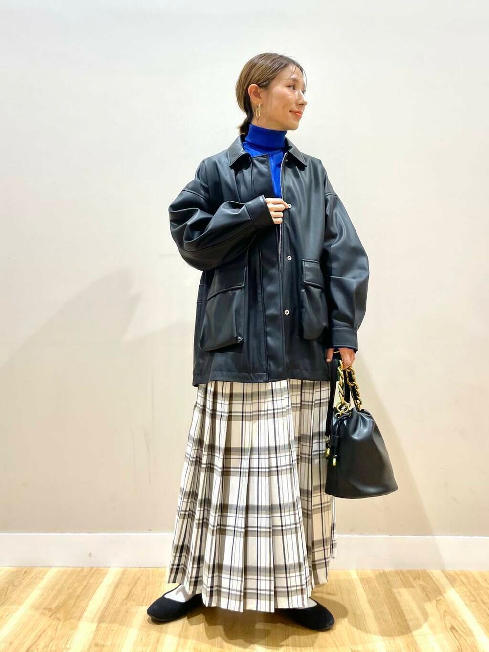 ブラック系のショルダーバッグ、ブラック系のその他アウター、ブルー系のニット/セーターを着用したレディースの冬コーディネートの4枚目の写真