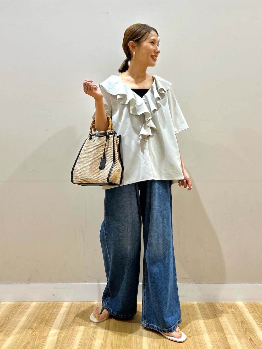 グレー系のシャツ/ブラウス、ブルー系のデニムパンツ、ブラック系のショルダーバッグを着用したレディースの夏コーディネートの2枚目の写真