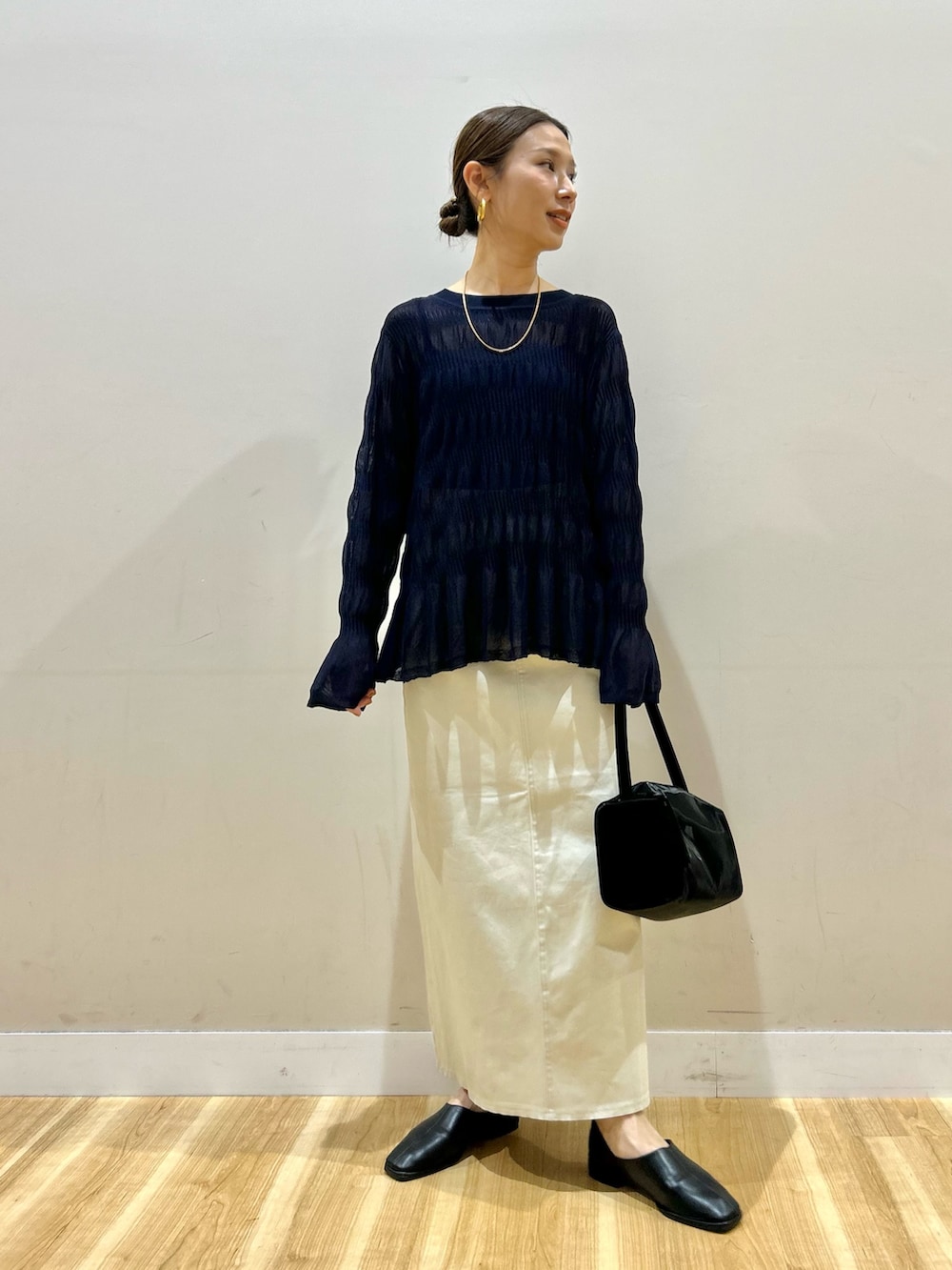 グレー系のパーカー、ブルー系のニット/セーター、ブラック系のスリッポンを着用したレディースの春コーディネートの4枚目の写真