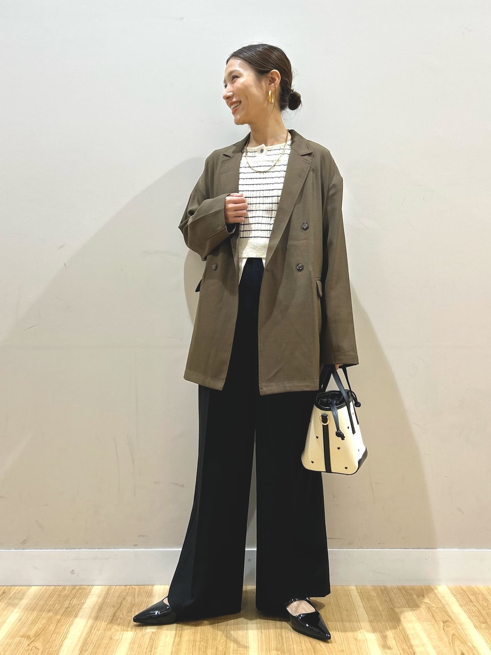 ブラウン系のその他アウター、ホワイト系のニット/セーター、ブラック系のその他パンツを着用したレディースの春コーディネートの4枚目の写真