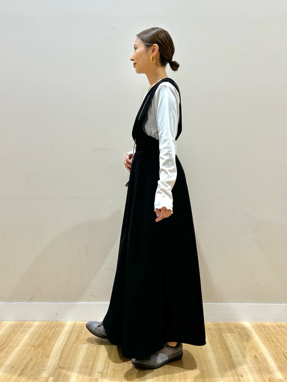 ブラック系のワンピース、その他のショルダーバッグ、グレー系のスニーカーを着用したレディースの春コーディネートの2枚目の写真