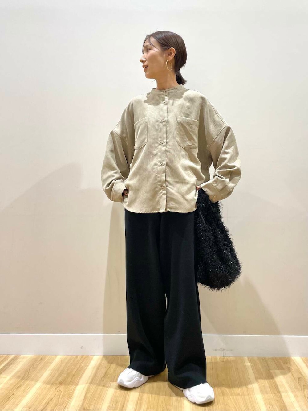 ホワイト系のスニーカー、ベージュ系のTシャツ/カットソー、ブラック系のダウンジャケット/コートを着用したレディースの冬コーディネートの6枚目の写真