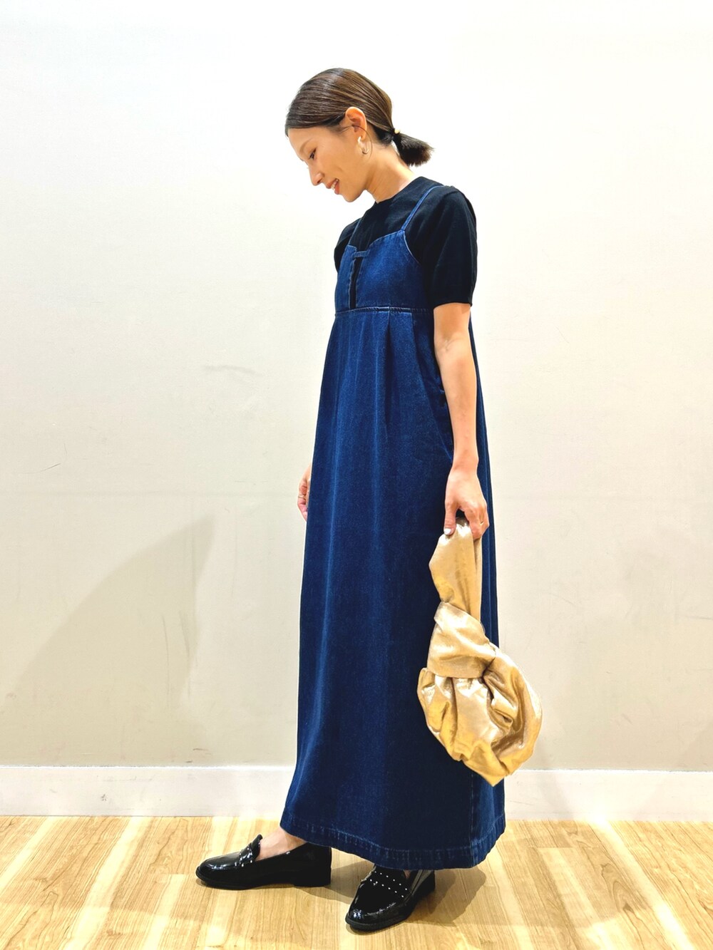 ブルー系のワンピース、ブラック系のニット/セーター、ゴールド系のハンドバッグを着用したレディースの夏コーディネートの2枚目の写真