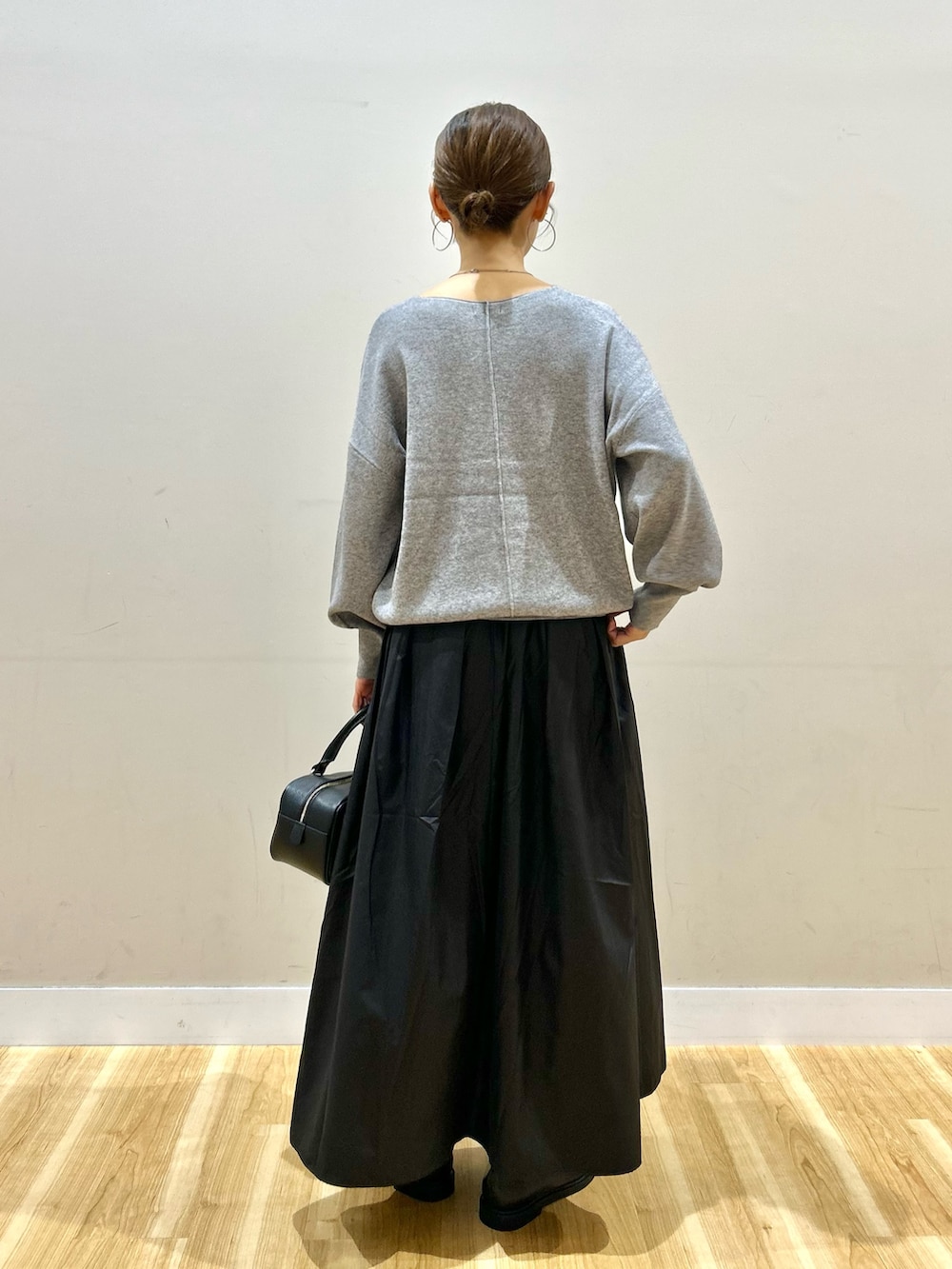 ブルー系のデニムジャケット、グレー系のニット/セーター、ブラック系のスカートを着用したレディースの秋コーディネートの8枚目の写真
