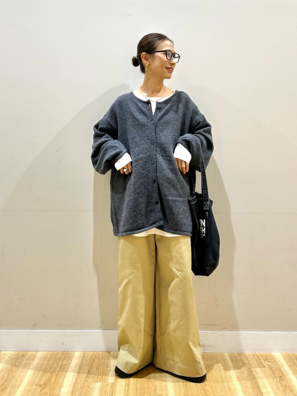 グレー系のニット/セーター、ホワイト系のシャツ/ブラウス、ベージュ系のその他パンツを着用したレディースの秋コーディネートの5枚目の写真