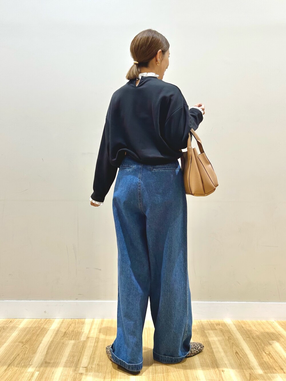 ブラック系のスウェット、ブルー系のデニムパンツ、その他のローファーを着用したレディースの秋コーディネートの3枚目の写真