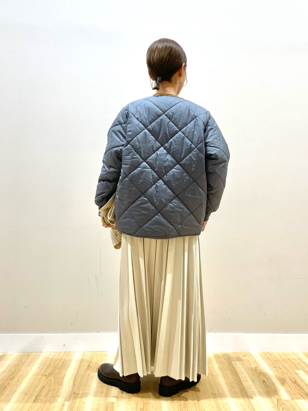 グレー系のニット/セーター、グレー系のダウンジャケット/コート、ホワイト系のTシャツ/カットソーを着用したレディースの冬コーディネートの3枚目の写真