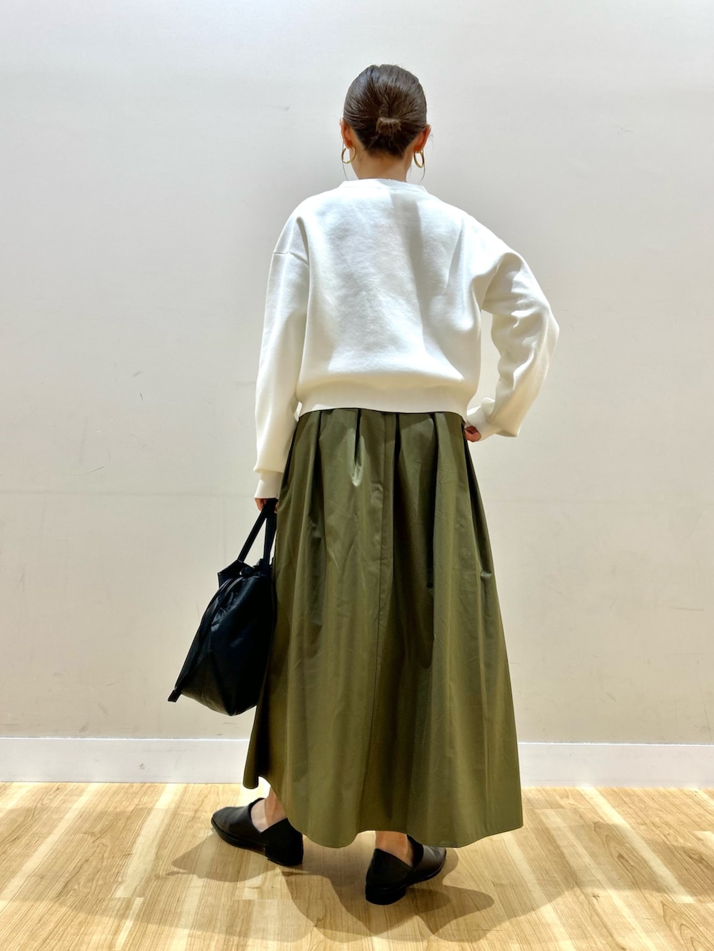 ホワイト系のカーディガン/ボレロ、ホワイト系のニット/セーター、グリーン系のスカートを着用したレディースの春コーディネートの3枚目の写真