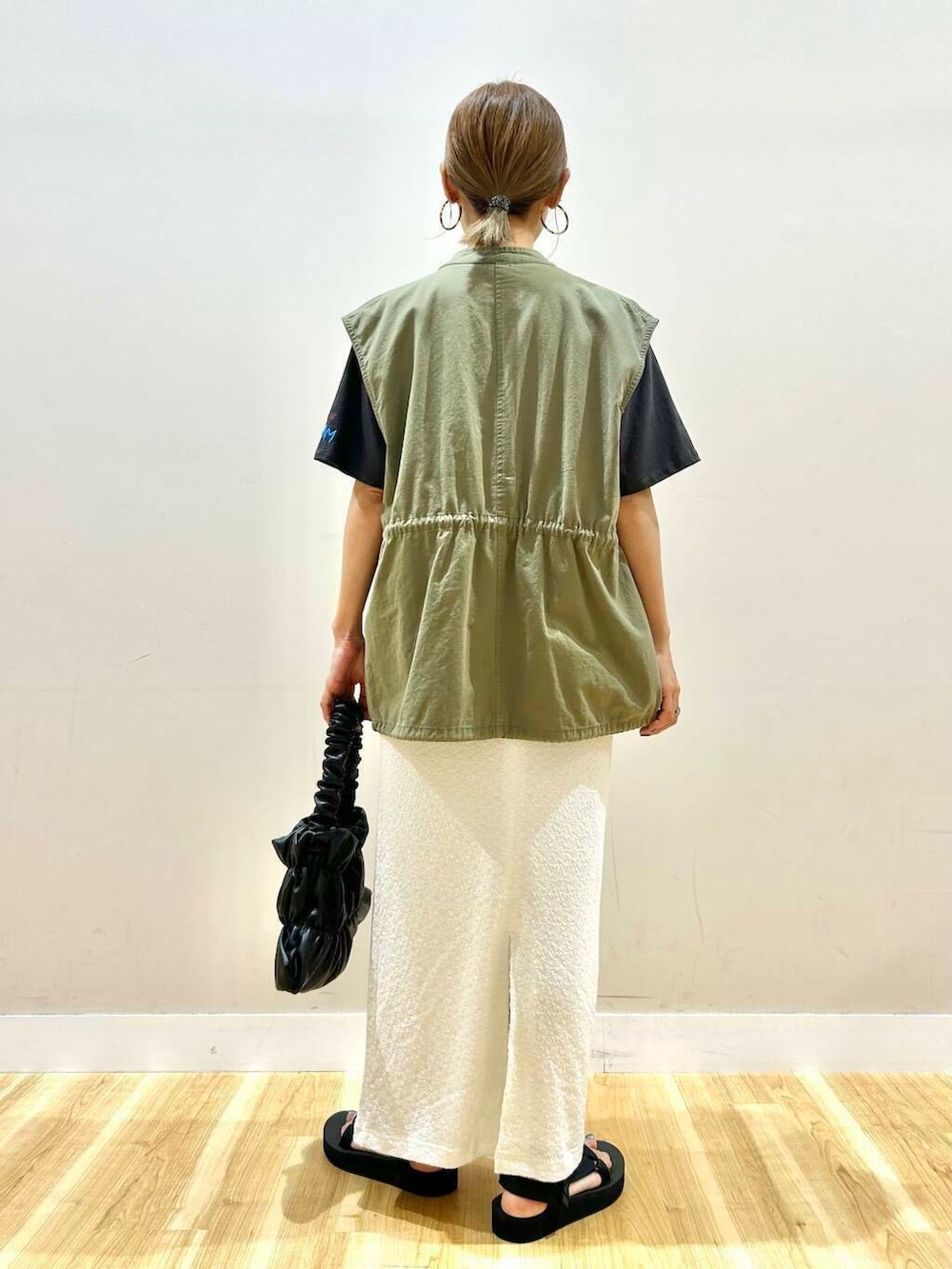 ブラック系のサンダル、ブラック系のハンドバッグ、グリーン系のその他アウターを着用したレディースの夏コーディネートの4枚目の写真