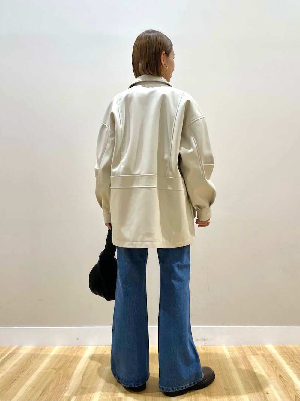 ブラウン系のブーツ、ブルー系のデニムパンツ、ブラック系のハンドバッグを着用したレディースの秋コーディネートの3枚目の写真