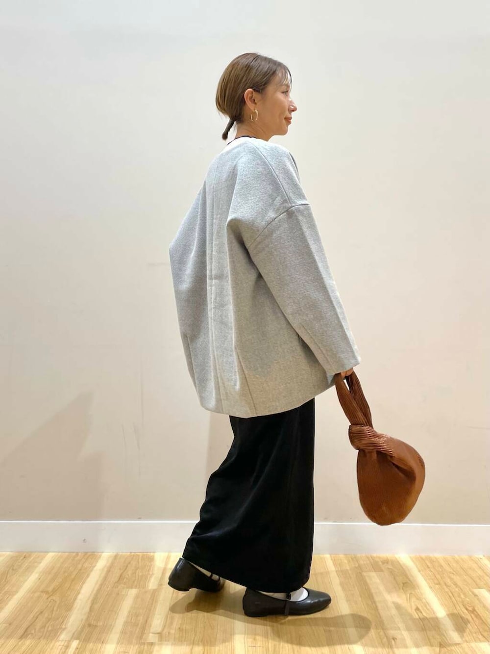 ブラック系のパンプス、ブラウン系のハンドバッグ、ホワイト系のニット/セーターを着用したレディースの冬コーディネートの5枚目の写真