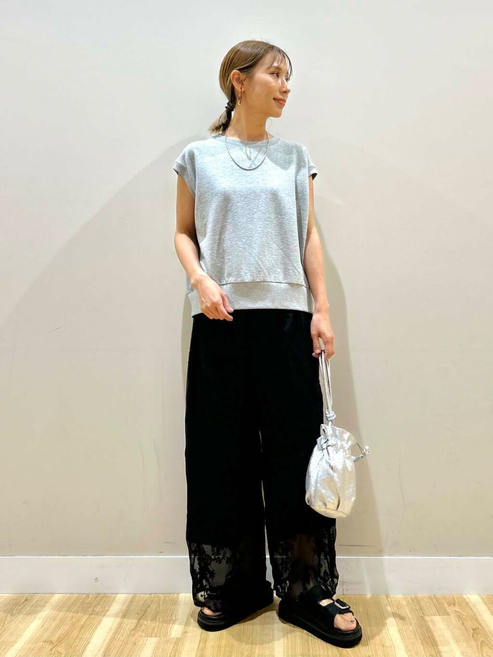 シルバー系のショルダーバッグ、ブラック系のその他パンツ、グレー系のベストを着用したレディースの夏コーディネートの4枚目の写真