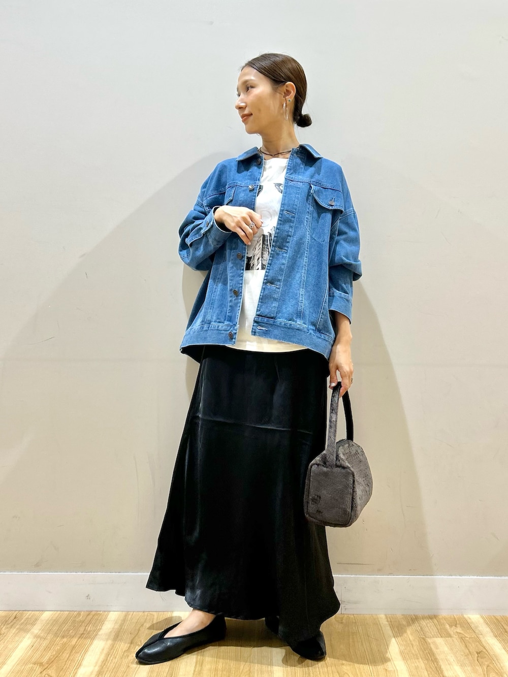 ブルー系のカバーオール、ホワイト系のTシャツ/カットソー、ブラック系のスカートを着用したレディースの秋コーディネートの5枚目の写真