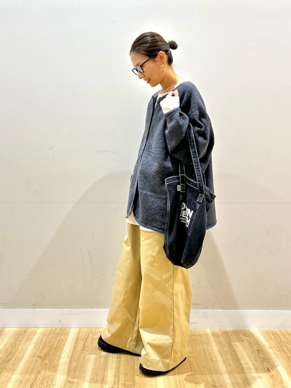 グレー系のニット/セーター、ホワイト系のシャツ/ブラウス、ベージュ系のその他パンツを着用したレディースの秋コーディネートの2枚目の写真