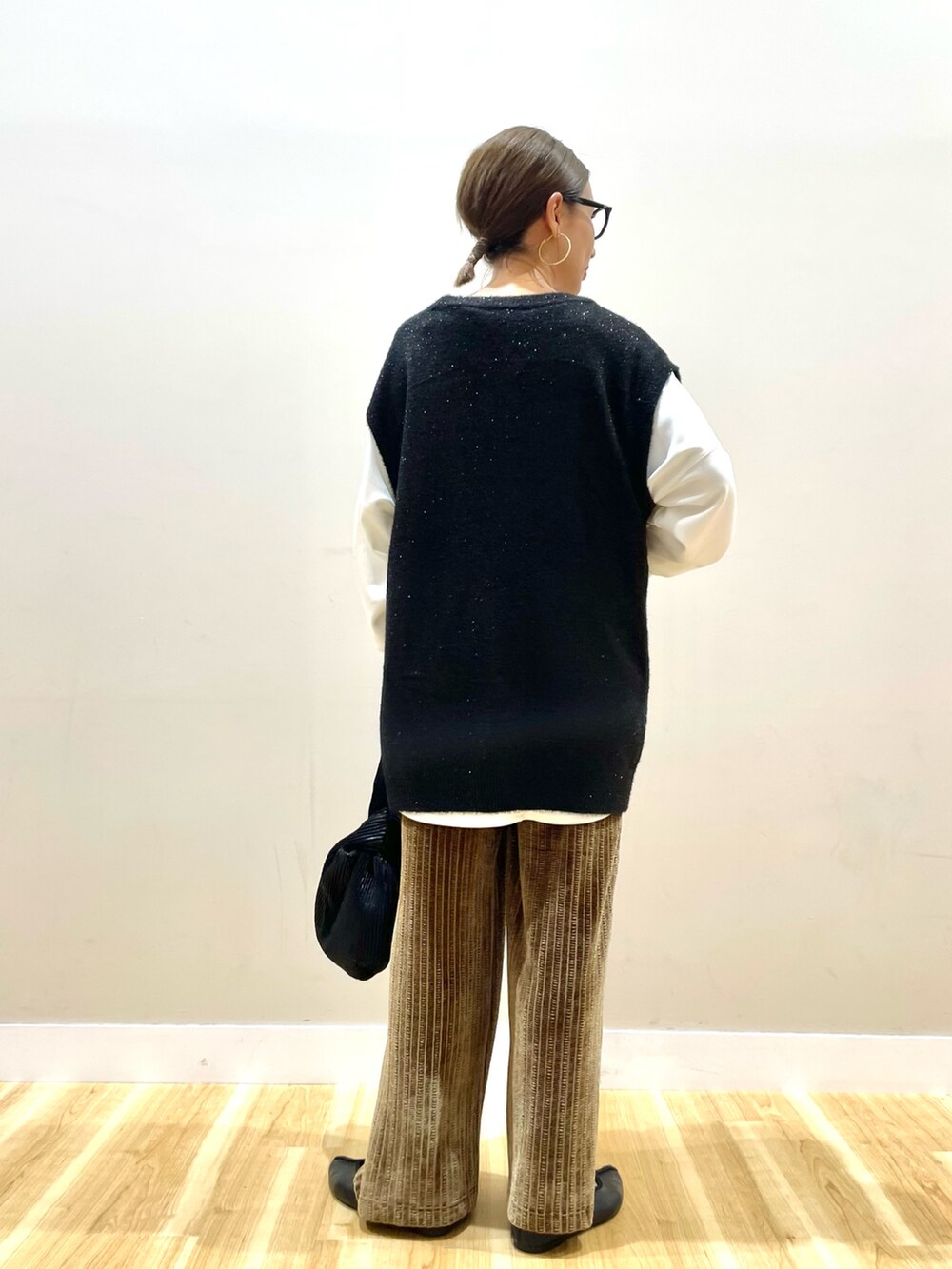 ブラック系のベスト、ホワイト系のTシャツ/カットソー、ブラウン系のその他パンツを着用したレディースの秋コーディネートの4枚目の写真