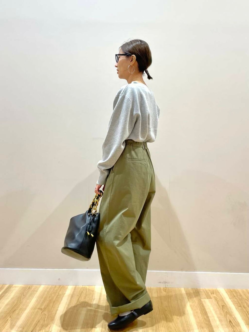 ブラック系のパンプス、ブラック系のショルダーバッグ、グレー系のニット/セーターを着用したレディースの秋コーディネートの4枚目の写真