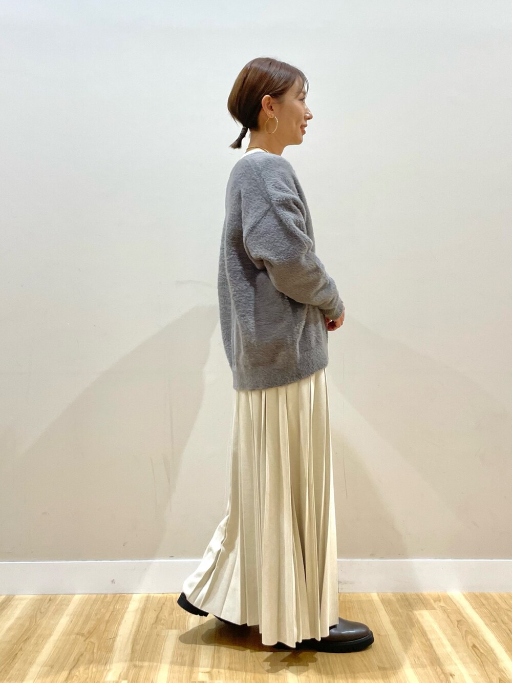 グレー系のニット/セーター、グレー系のダウンジャケット/コート、ホワイト系のTシャツ/カットソーを着用したレディースの冬コーディネートの6枚目の写真