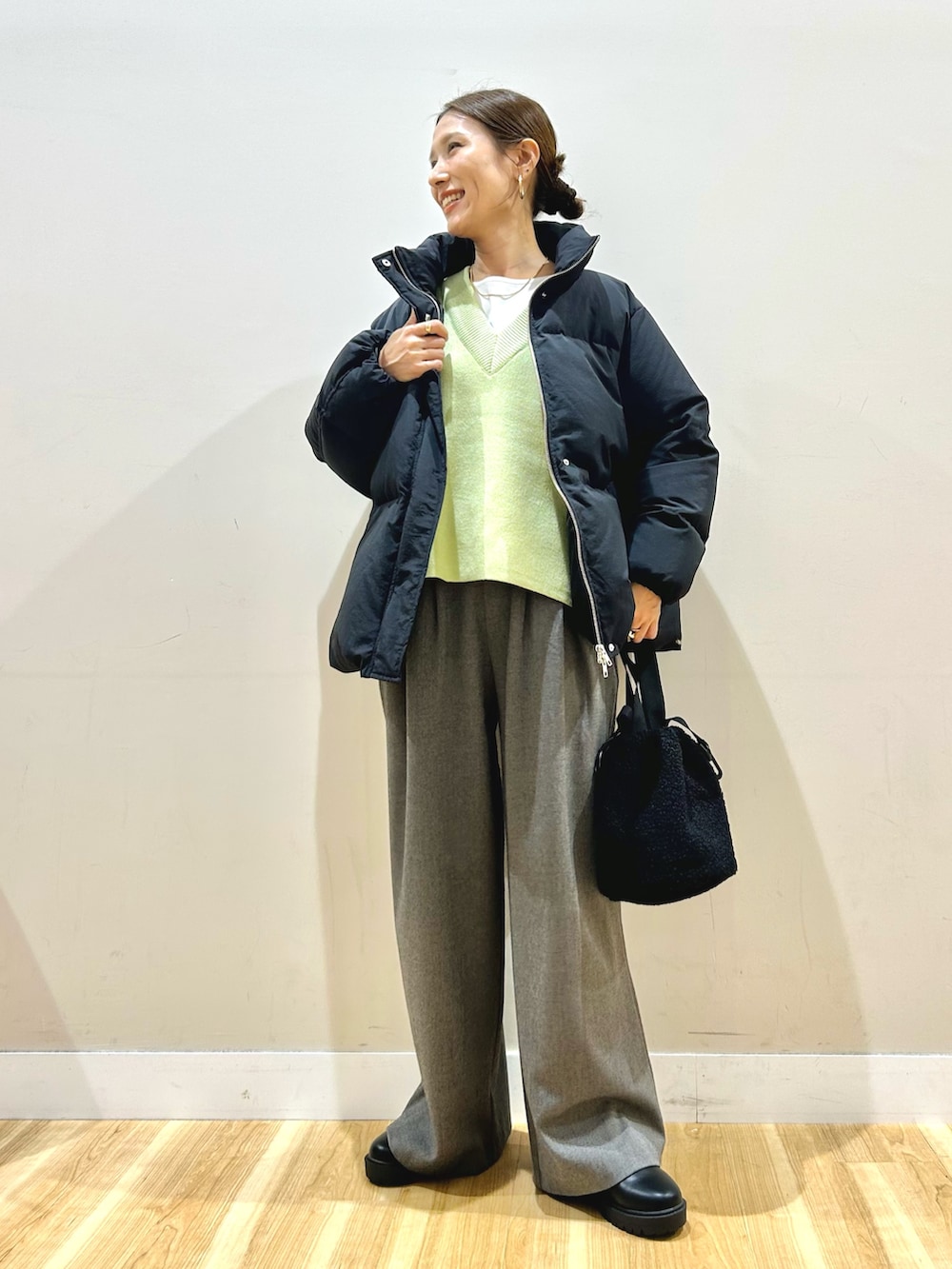 ブラック系のダウンジャケット/コート、ホワイト系のTシャツ/カットソー、ブラック系のブーツを着用したレディースの冬コーディネートの8枚目の写真