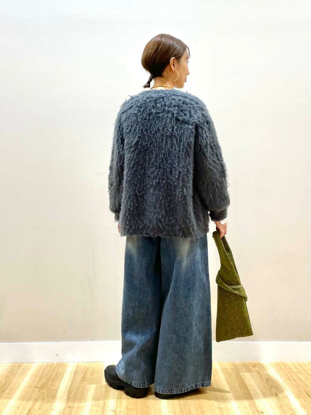 グレー系のカーディガン/ボレロ、ゴールド系のトートバッグ、ブラック系のブーツを着用したレディースの冬コーディネートの3枚目の写真