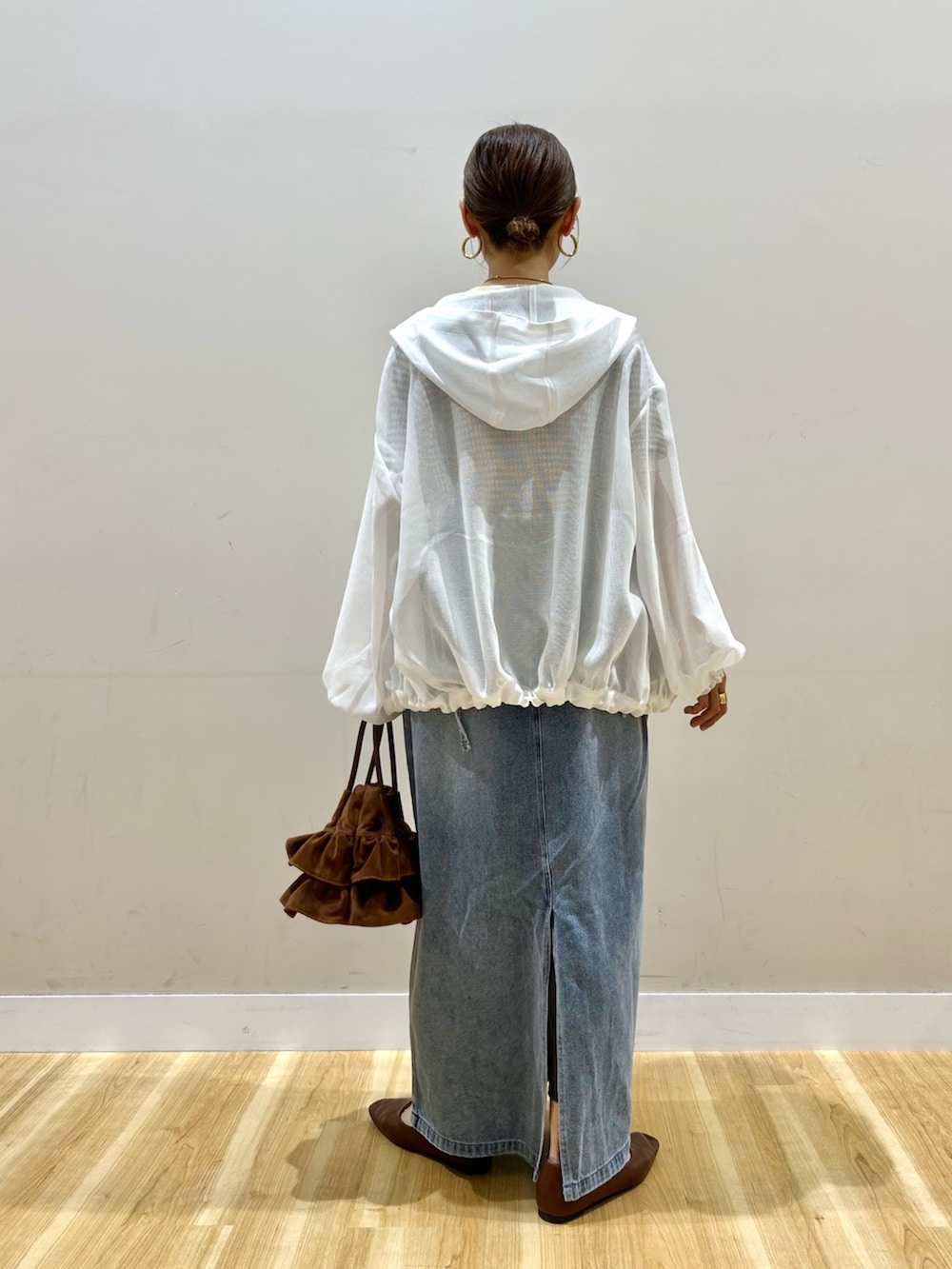 ホワイト系のマウンテンパーカー、ブラウン系のニット/セーター、ブルー系のワンピースを着用したレディースの春コーディネートの3枚目の写真