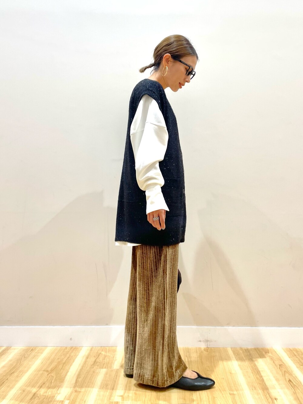 ブラック系のベスト、ホワイト系のTシャツ/カットソー、ブラウン系のその他パンツを着用したレディースの秋コーディネートの3枚目の写真