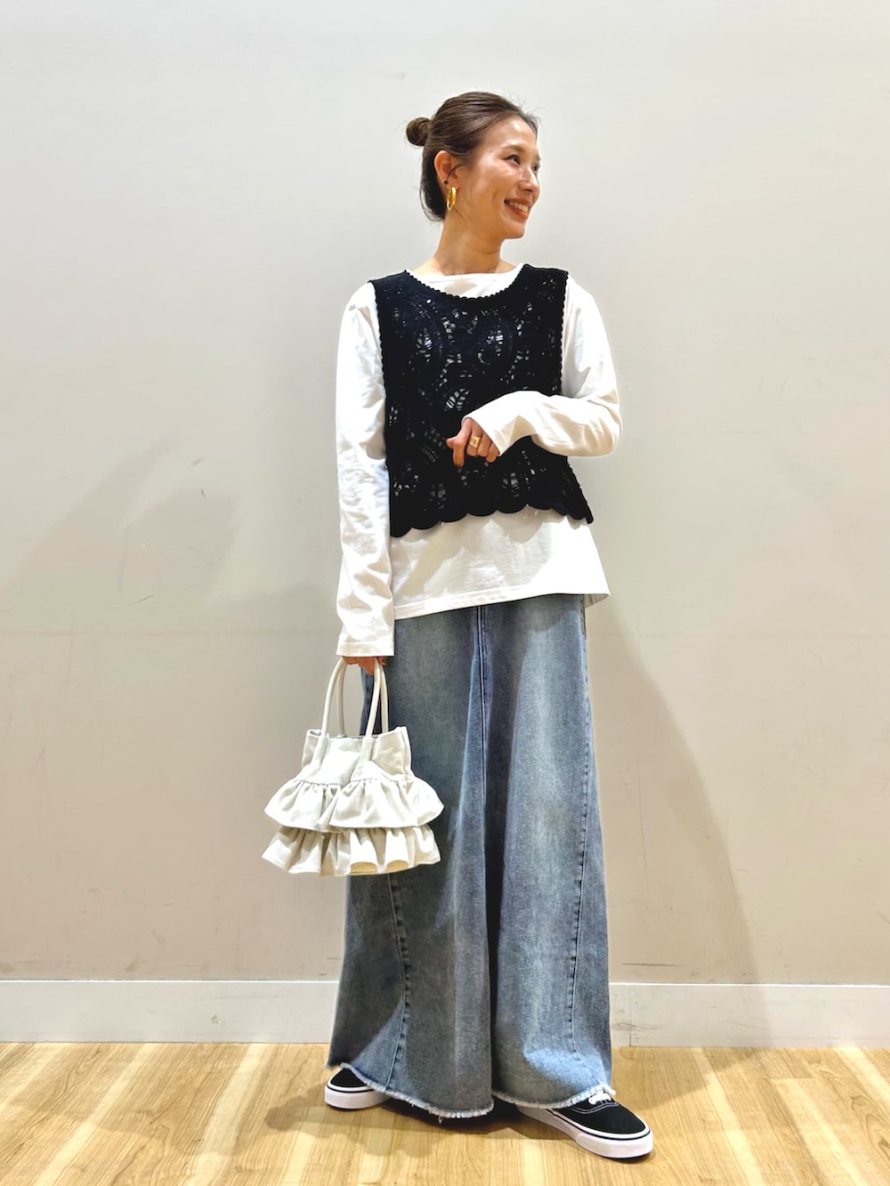 グリーン系のブルゾン、ブラック系のTシャツ/カットソー、ブルー系のスカートを着用したレディースの春コーディネートの4枚目の写真