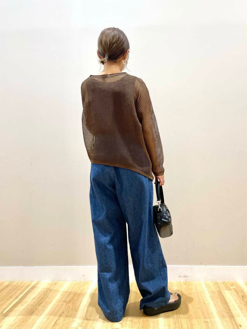 ブラウン系のタンクトップ、ブラック系のショルダーバッグ、ブルー系のデニムパンツを着用したレディースの夏コーディネートの3枚目の写真