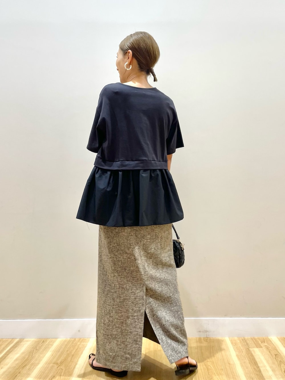 ブラック系のTシャツ/カットソー、ベージュ系のスカート、ブラック系のショルダーバッグを着用したレディースの夏コーディネートの3枚目の写真