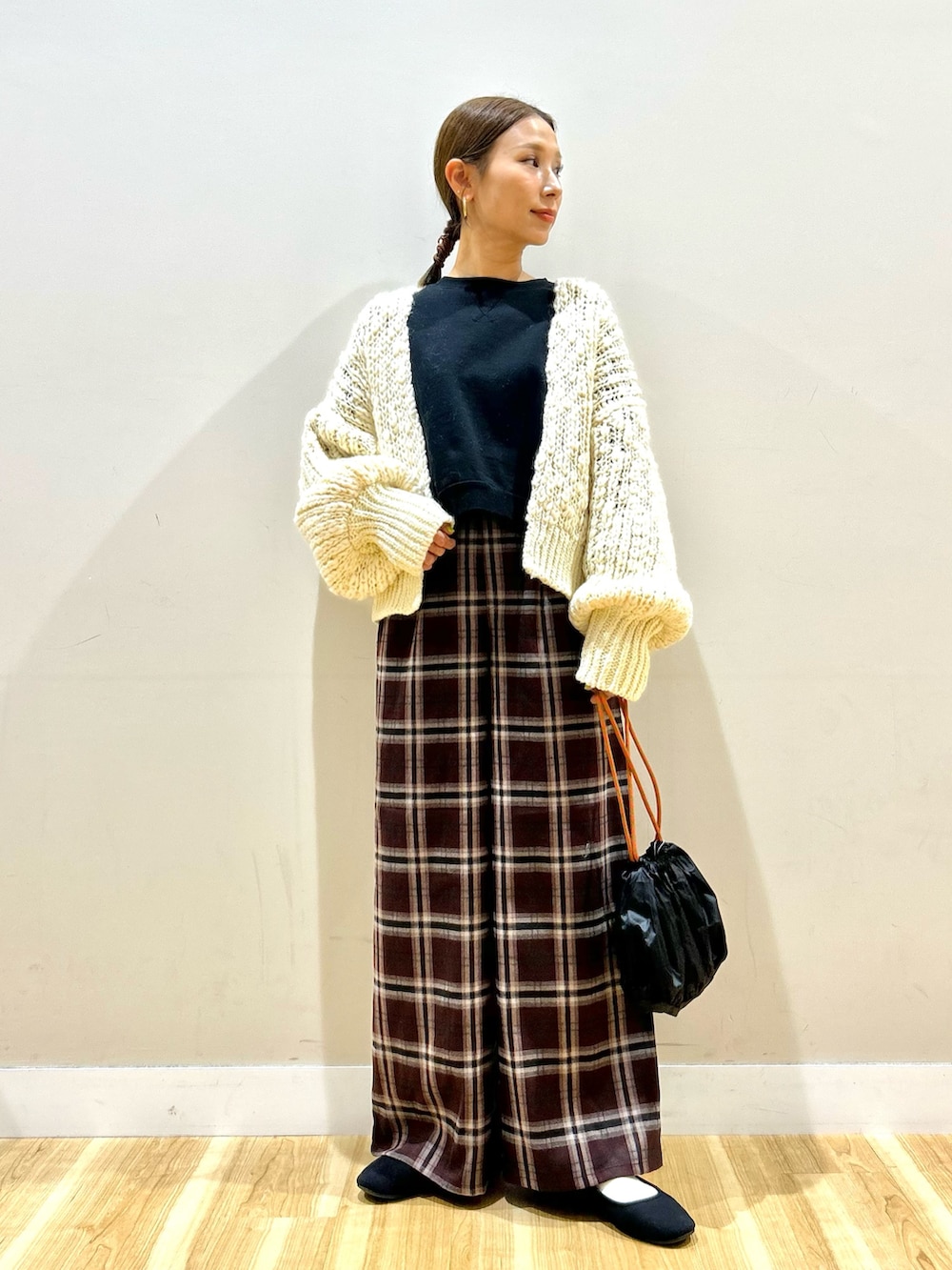 ホワイト系のカーディガン/ボレロ、ブラック系のスウェット、レッド系のその他パンツを着用したレディースの冬コーディネートの6枚目の写真