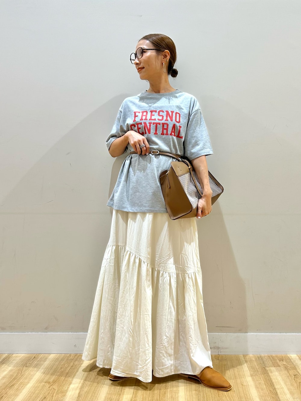 グレー系のTシャツ/カットソー、ブラウン系のショルダーバッグ、ホワイト系のスカートを着用したレディースの秋コーディネートの5枚目の写真