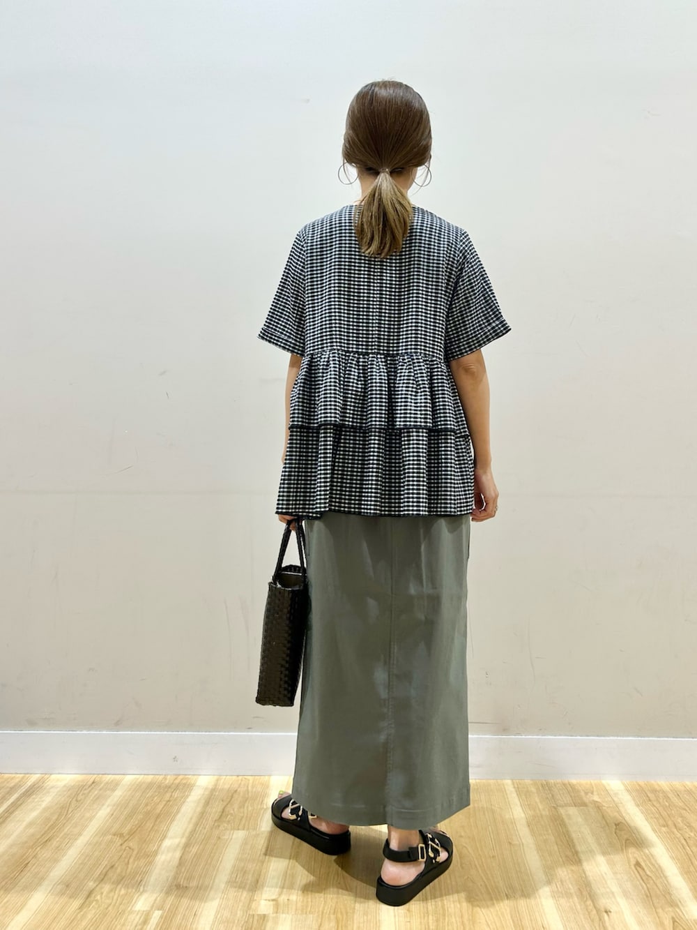 ブラック系のシャツ/ブラウス、グリーン系のスカート、ブラウン系のトートバッグを着用したレディースの夏コーディネートの3枚目の写真