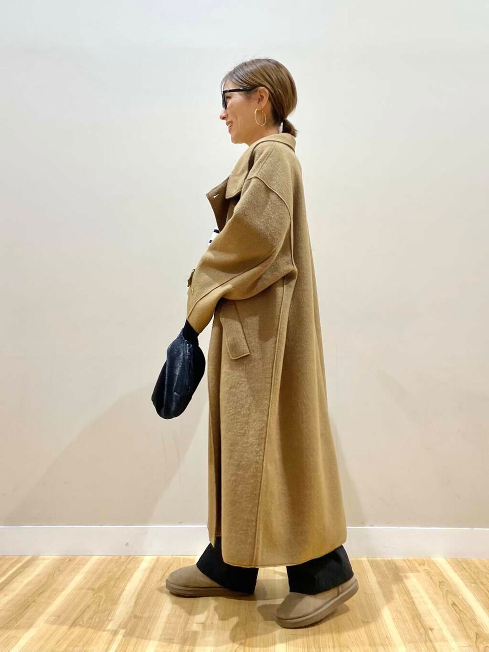 ブラック系のハンドバッグ、ブラック系のニット/セーター、ブラック系のデニムパンツを着用したレディースの秋コーディネートの4枚目の写真