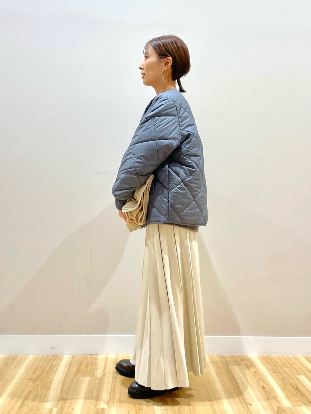 グレー系のニット/セーター、グレー系のダウンジャケット/コート、ホワイト系のTシャツ/カットソーを着用したレディースの冬コーディネートの4枚目の写真