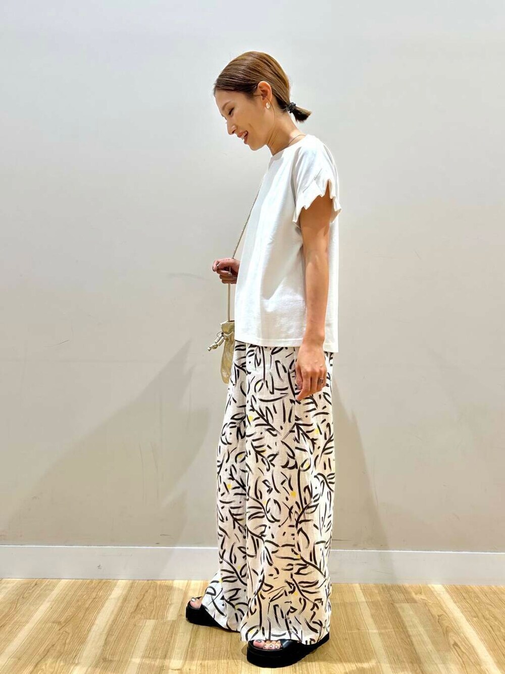 ゴールド系のショルダーバッグ、ホワイト系のその他パンツ、ホワイト系のTシャツ/カットソーを着用したレディースの夏コーディネートの8枚目の写真