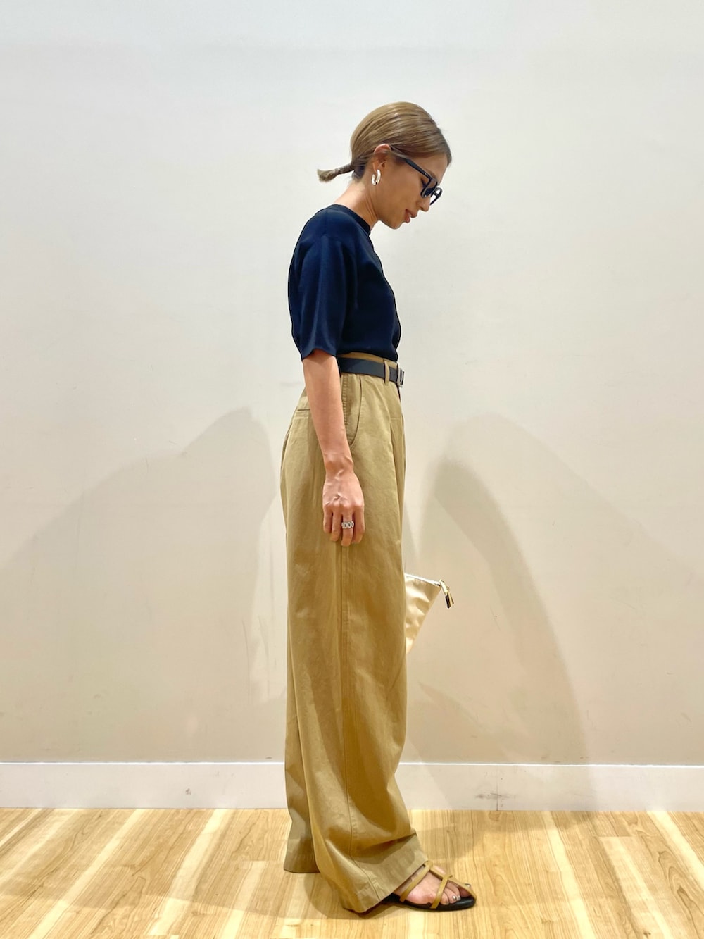 ブラック系のニット/セーター、イエロー系のチノパンツを着用したレディースの夏コーディネートの2枚目の写真