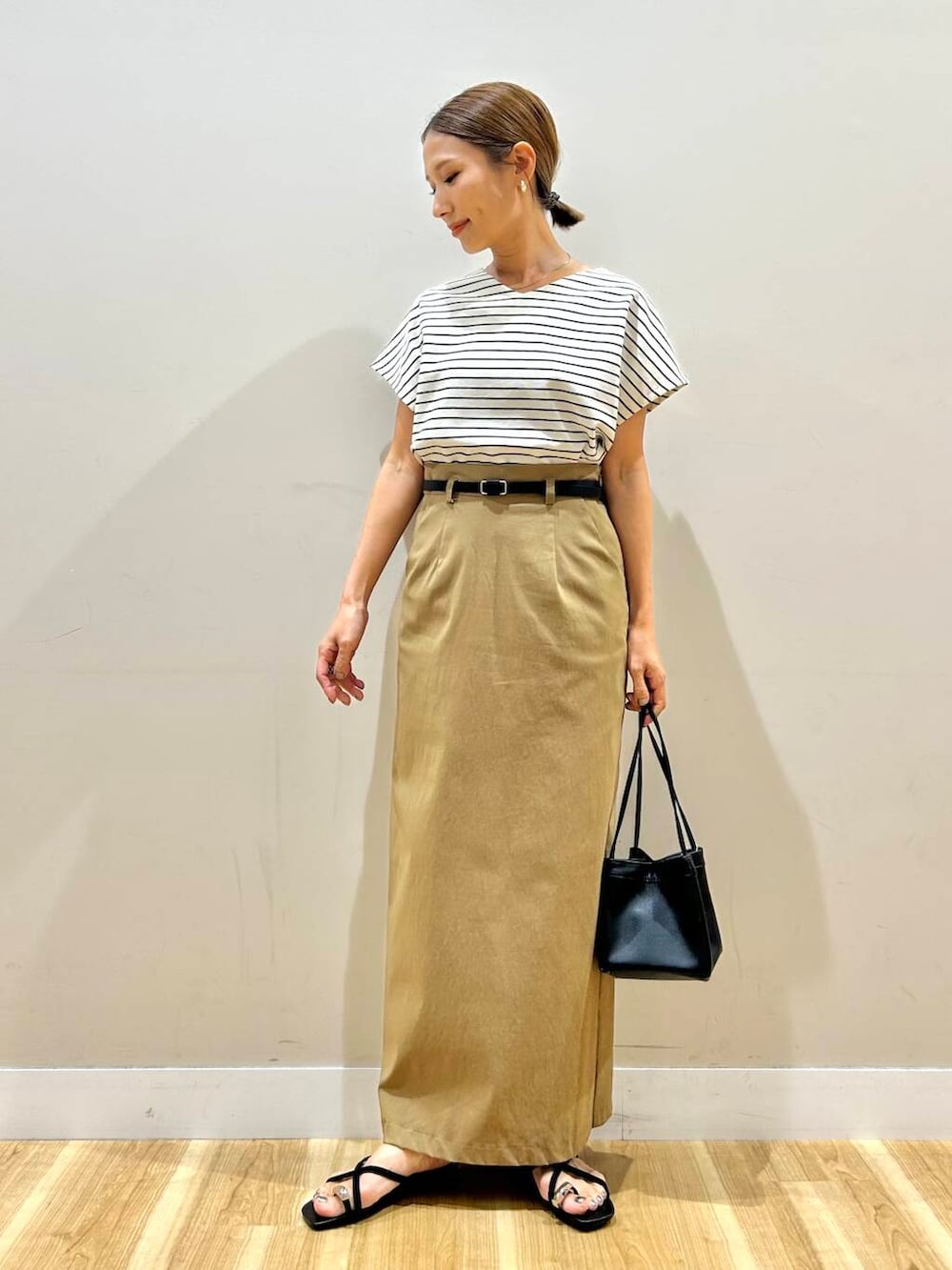 ホワイト系のTシャツ/カットソー、ブラック系のハンドバッグ、イエロー系のスカートを着用したレディースの夏コーディネートの5枚目の写真