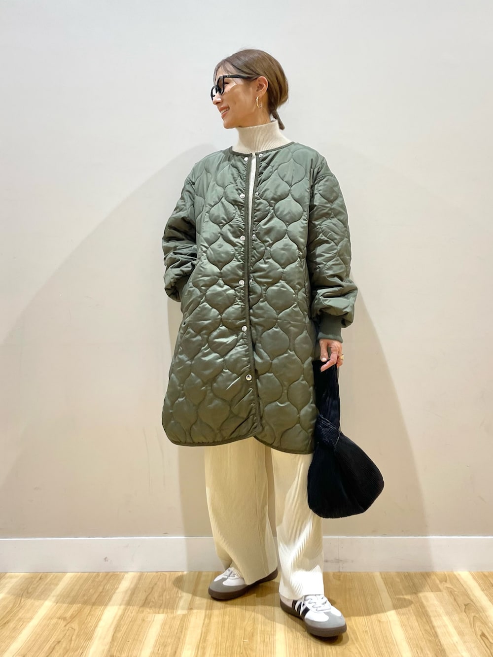 グリーン系のその他アウター、ホワイト系のその他パンツ、ホワイト系のニット/セーターを着用したレディースの冬コーディネートの3枚目の写真