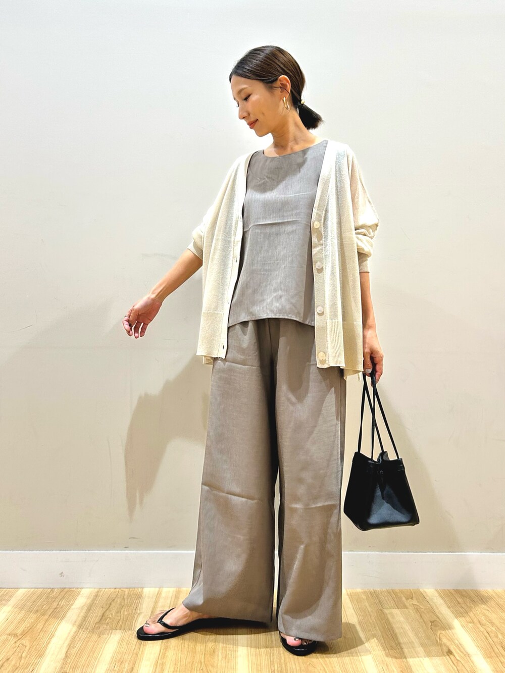 グレー系のカーディガン/ボレロ、ベージュ系のセットアップを着用したレディースの秋コーディネートの2枚目の写真